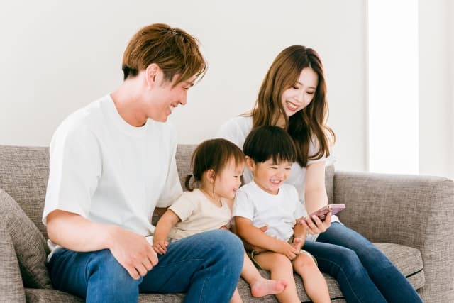 親子が笑顔でスマートフォンを見ている様子